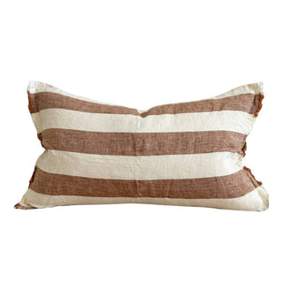 Rust and off-white wide stripe linen lumbar cushion cover with frayed edges and stonewashed texture. 