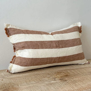 Striped brown and white linen cushion with frayed edges and stonewashed texture.