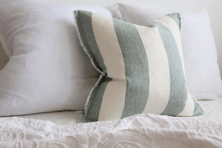 Striped linen cushion in teal and white for for bed and sofa styling.