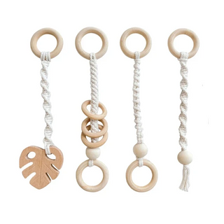 Wood and macrame baby hanging toy pendant in neutral tones, attached to a play gym, handcrafted for sensory play and motor skill development.