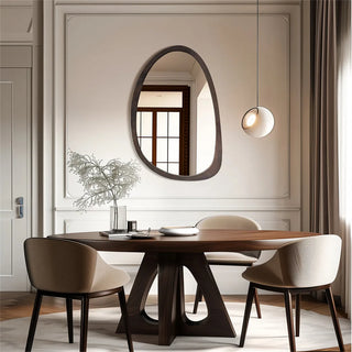 Abstract wooden wall mirror above a dining table with a round pendant light