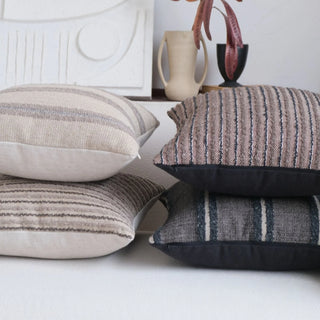 Stack of Kaya linen blend cushion covers in coffee, natural and black stripes